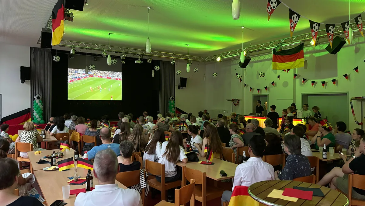 Gemeindesaal der Aue mit Fußballfans die ein Fußballspiel schauen