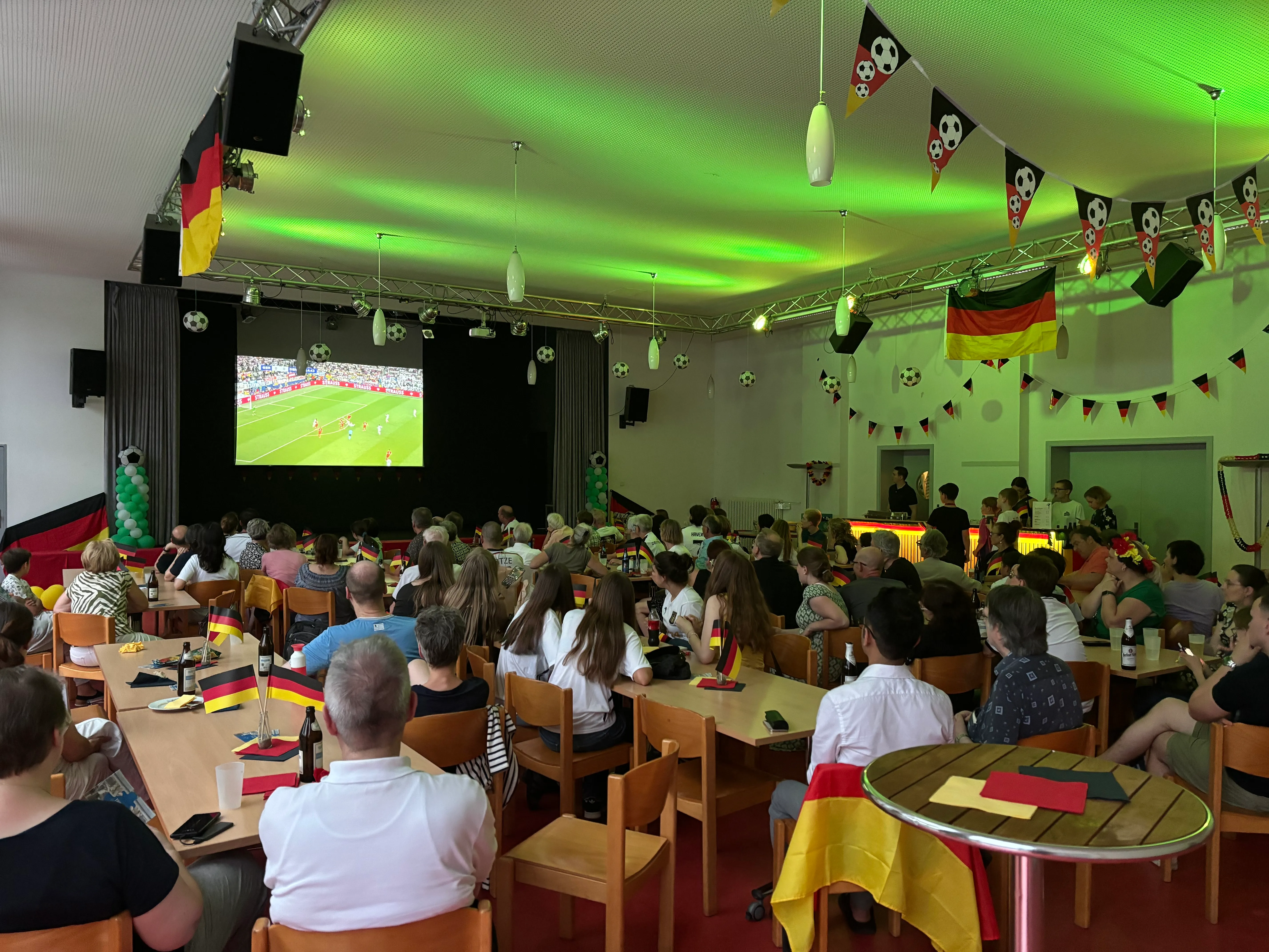 Gemeindesaal der Aue mit Fußballfans die ein Fußballspiel schauen