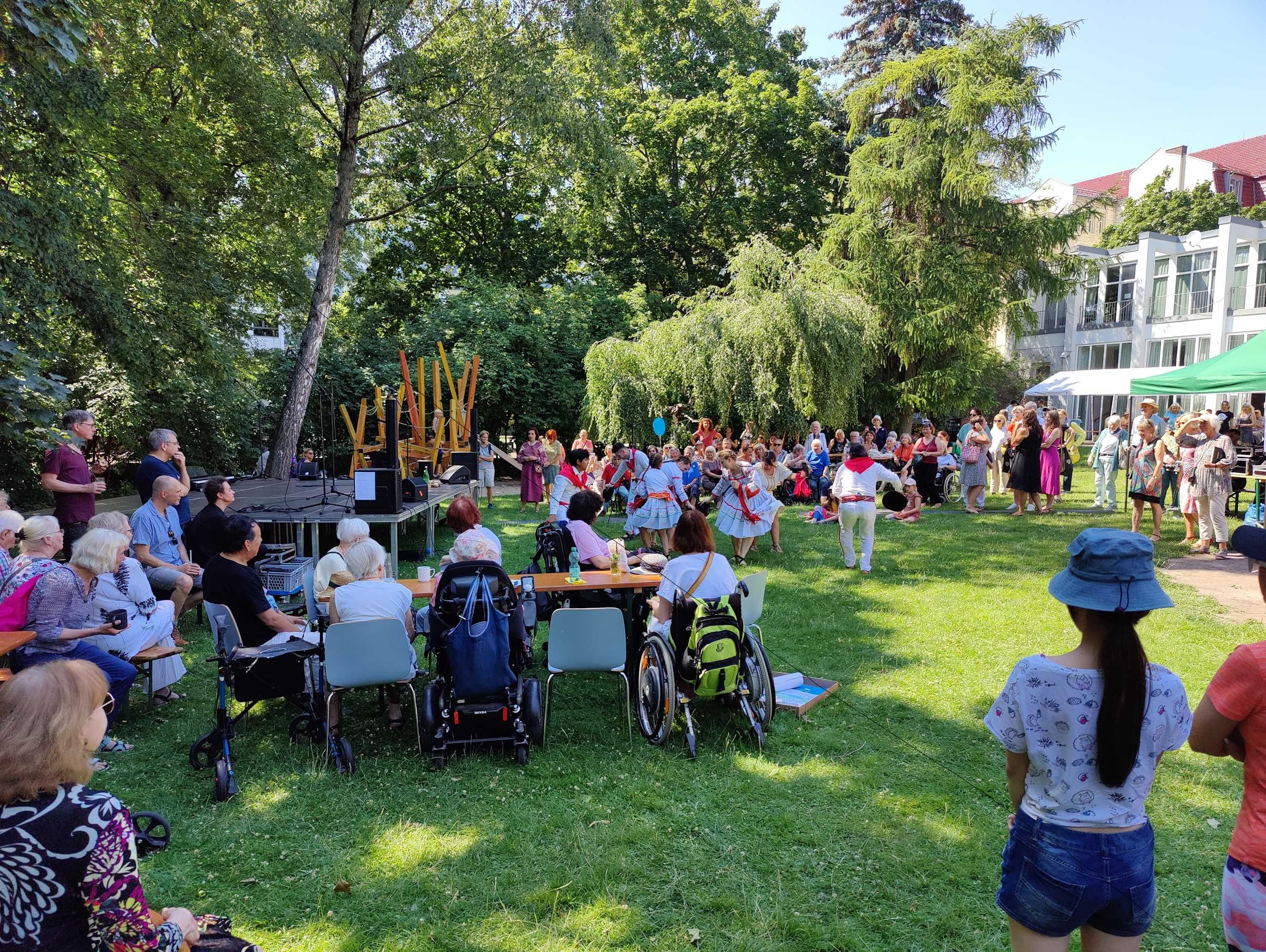 Menschen aller Generationen feiern ein Fest auf der Gemeindewiese