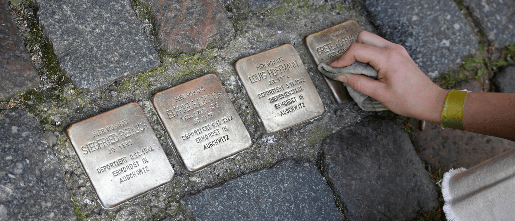 KI-gneriertes Bild: Perosn putzt einen Stolperstein auf der Straße
